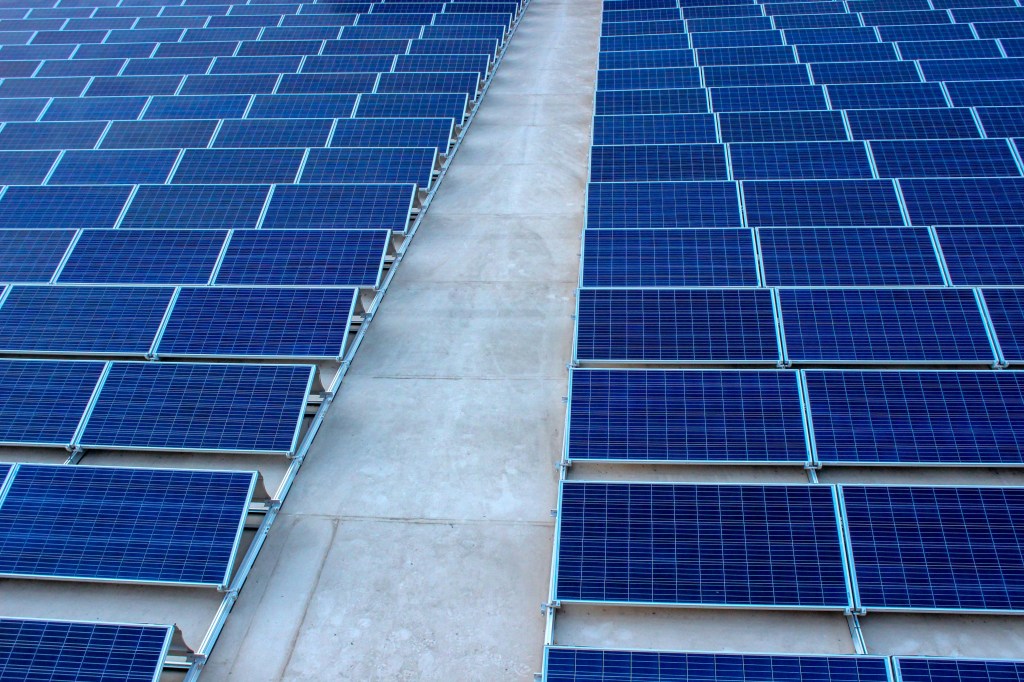 Close-up view of a large array of blue solar panels on a flat surface, showcasing sustainable energy solutions in Michigan.