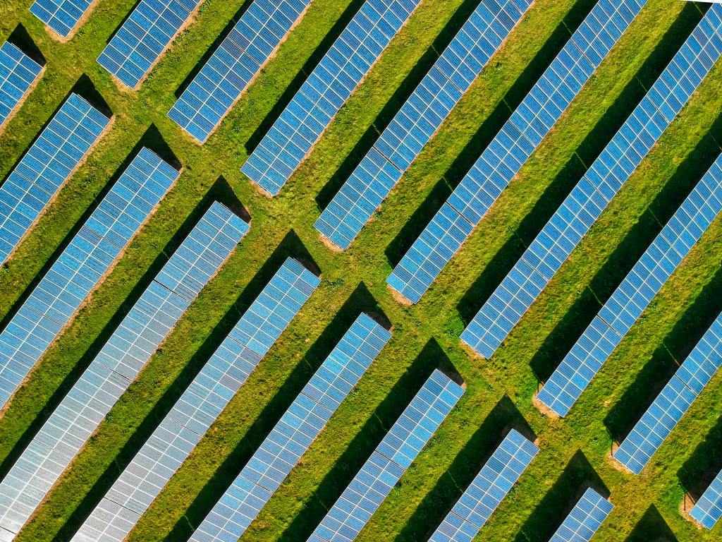 Aerial view of neatly arranged solar panels in diagonal rows on a Michigan solar farm, maximizing sunlight absorption