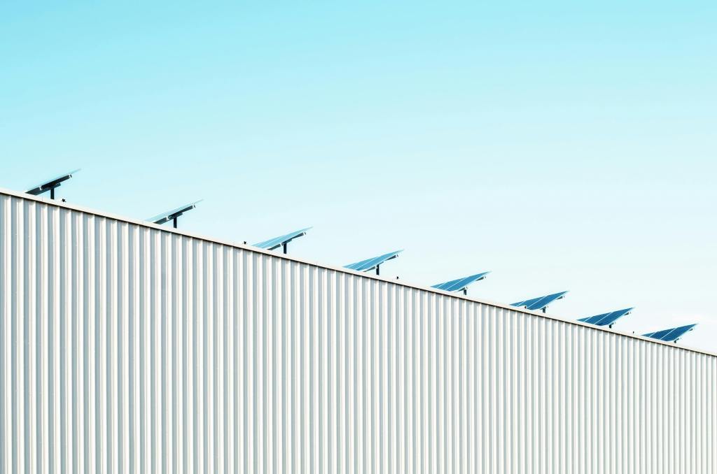 Rooftop solar panels on a Michigan industrial building against a clear blue sky, generating renewable energy