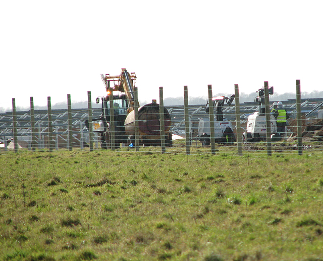 Solar panels installed above farmland in Michigan with crops growing beneath, demonstrating agrivoltaics and dual-use farming.